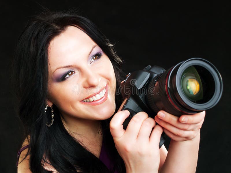 Macchina fotografica della holding della donna del fotografo sopra oscurità fotografia stock Macchina fotografica della holding della donna del fotografo sopra oscurità fotografia stock