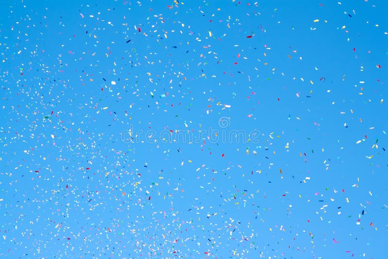 Colored confetti flying in the blue sky. Colored confetti flying in the blue sky
