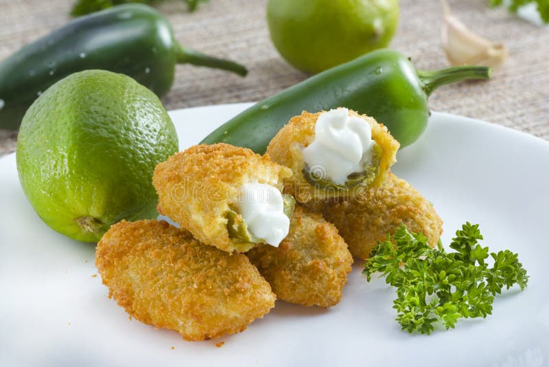 Mexican-american jalapeno poppers served with lime . Mexican-american jalapeno poppers served with lime .