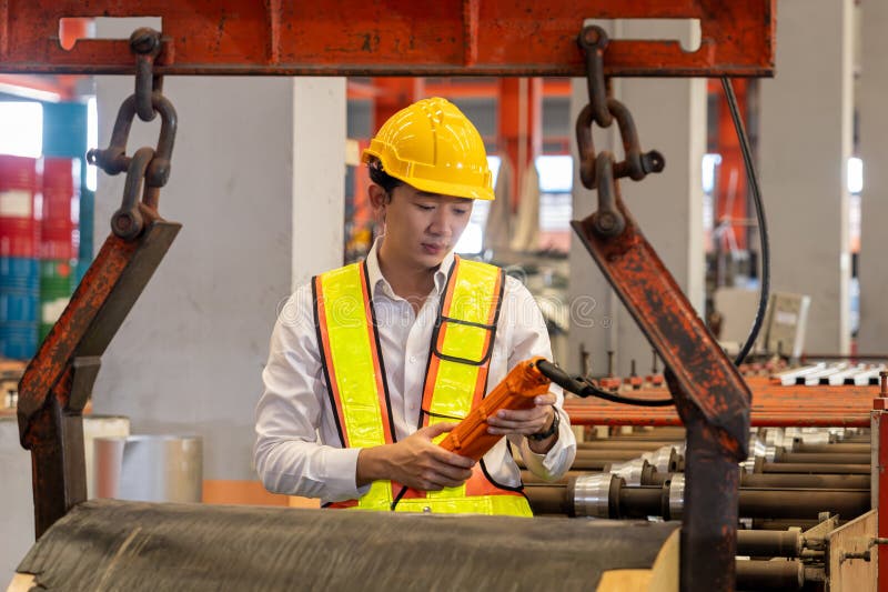 Machine operator skillfully operate steel forming machinery. Exemplifying stock photography