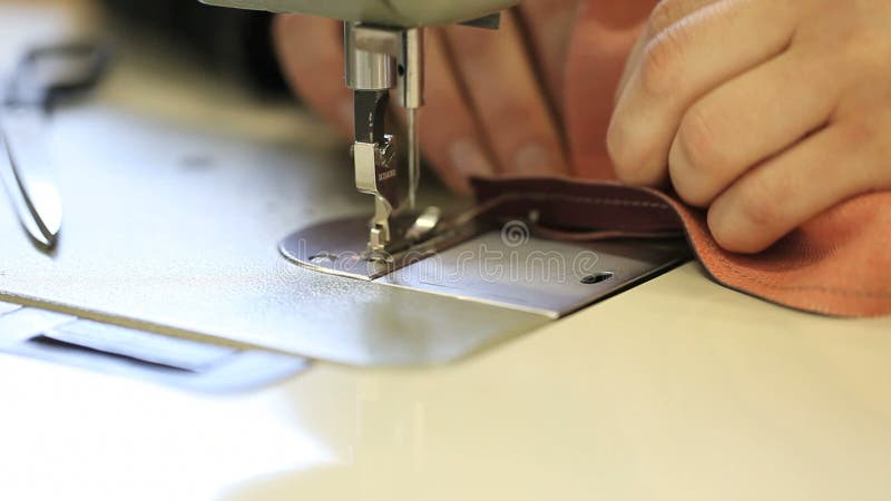Machine à coudre de mains dans un cuir de fabrication d'usine banque de vidéos