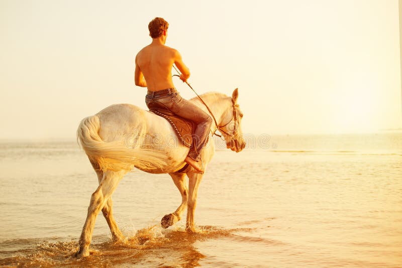 Macho man and horse on the background of sky and water. Boy mode