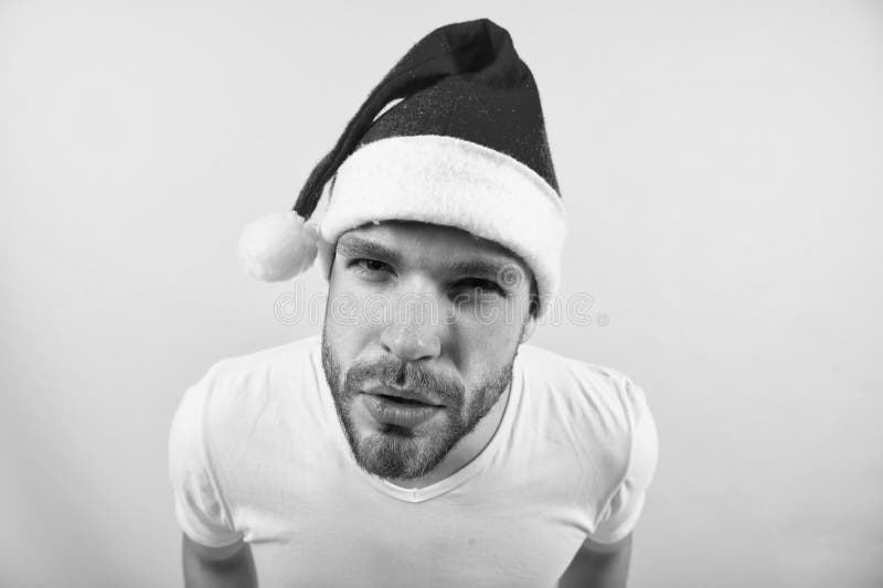 Macho in rode Kerstmishoed en witte t-shirt stock afbeelding Macho in rode Kerstmishoed en witte t-shirt stock afbeelding