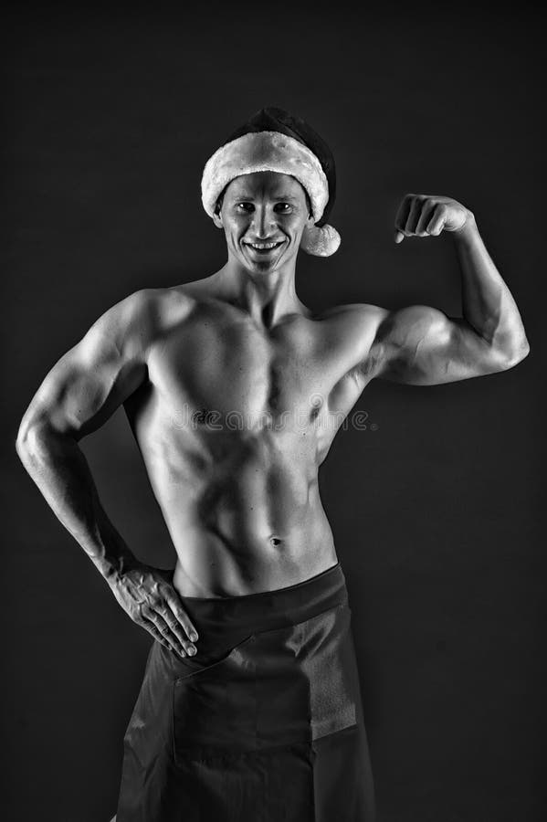 Macho sexy muscular torso posing confidently. Santa claus comes not only to good girls. Athlete man wear santa hat and royalty free stock photos Macho sexy muscular torso posing confidently. Santa claus comes not only to good girls. Athlete man wear santa hat and royalty free stock photos