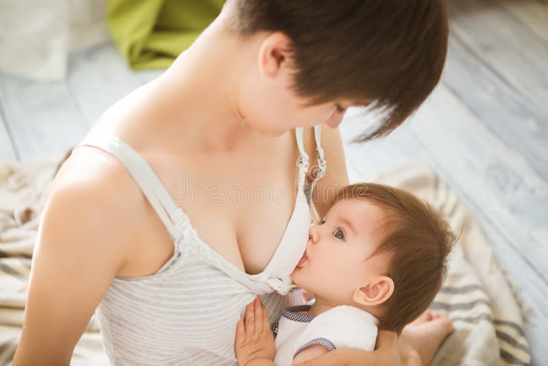 Macierzysty breastfeeding dziecko w ona ręki w domu Mamy pierś - karmić jej nowonarodzonego dziecka Dziecka łasowania matki ` s m