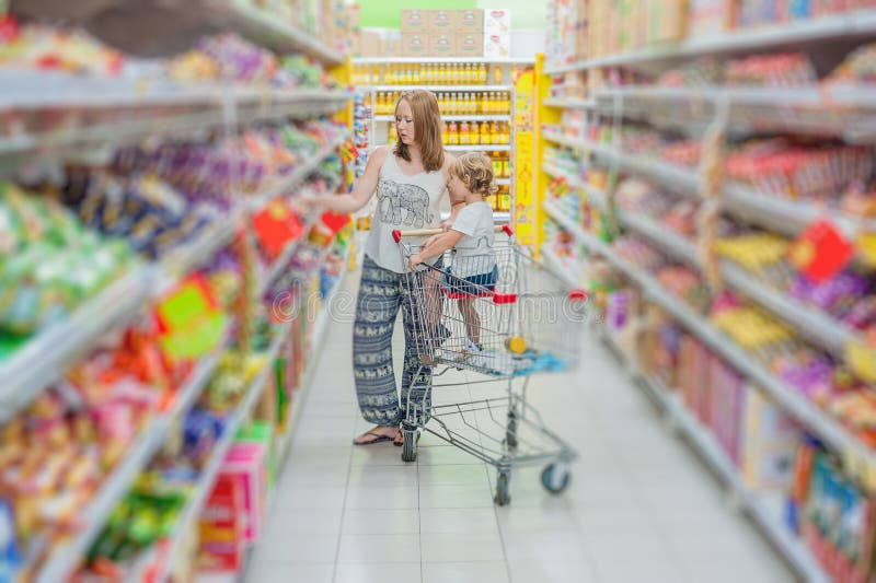 Macierzysty i syn jej kupienia jedzenie przy supermarketem zdjęcia stock Macierzysty i syn jej kupienia jedzenie przy supermarketem zdjęcia stock