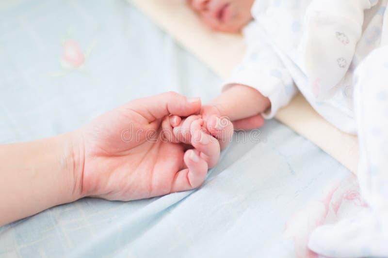 Mother holding the hand of her new born baby, shallow DOF. Mother holding the hand of her new born baby, shallow DOF