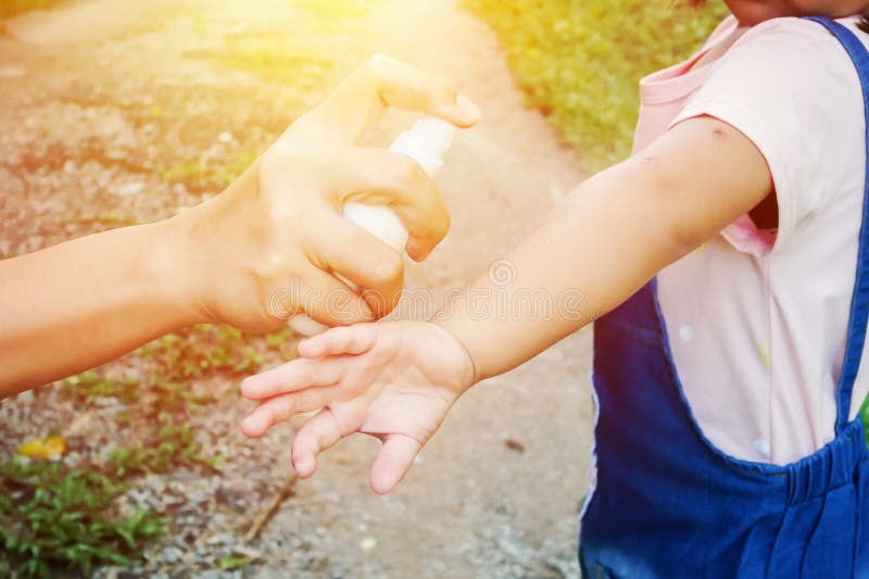 Macierzyści opryskiwanie komara lub insekta repellents na skóry dziewczynie, komara repellent dla dzieci obraz royalty free Macierzyści opryskiwanie komara lub insekta repellents na skóry dziewczynie, komara repellent dla dzieci obraz royalty free