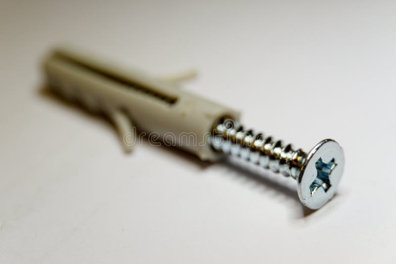 Macro close-up of chrome thread and beige dowel on white background in partial focus royalty free stock photography Macro close-up of chrome thread and beige dowel on white background in partial focus royalty free stock photography