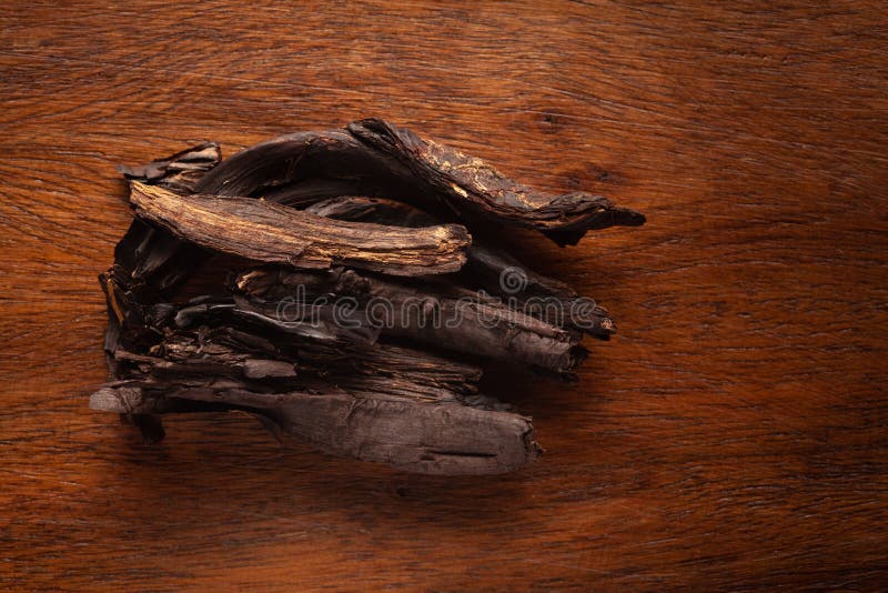 Macro close-up of Organic Alkanna tinctoria or ratan jot on wooden top background. Pile of Indian Aromatic Spice.