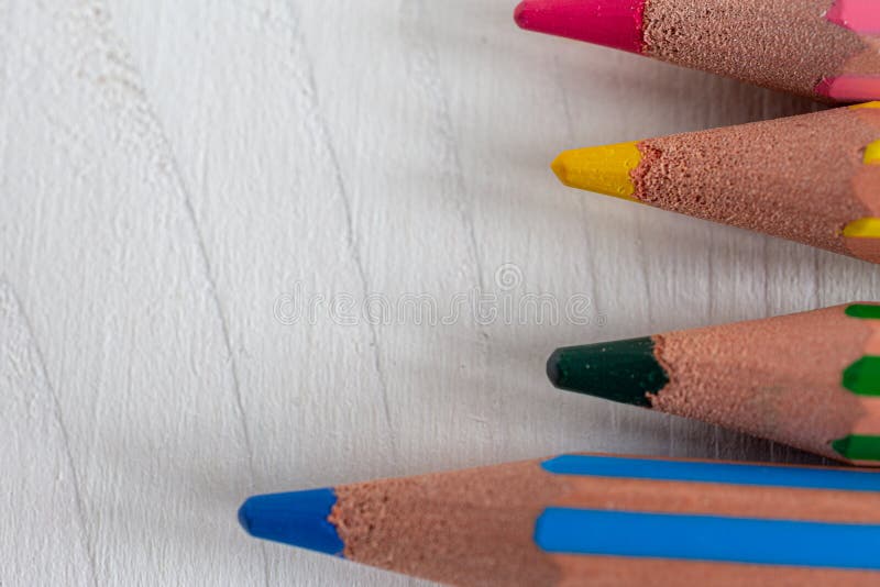 Macro closeup of several colored pencils for school, horizontally on white wood stock photography Macro closeup of several colored pencils for school, horizontally on white wood stock photography