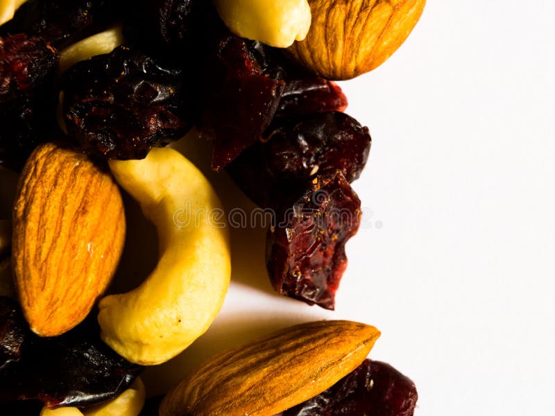 Macro colpo delle mandorle, delle arachidi, degli anacardi e dei mirtilli rossi secchi su fondo bianco con spazio per lo spazio d immagini stock libere da diritti Macro colpo delle mandorle, delle arachidi, degli anacardi e dei mirtilli rossi secchi su fondo bianco con spazio per lo spazio d immagini stock libere da diritti