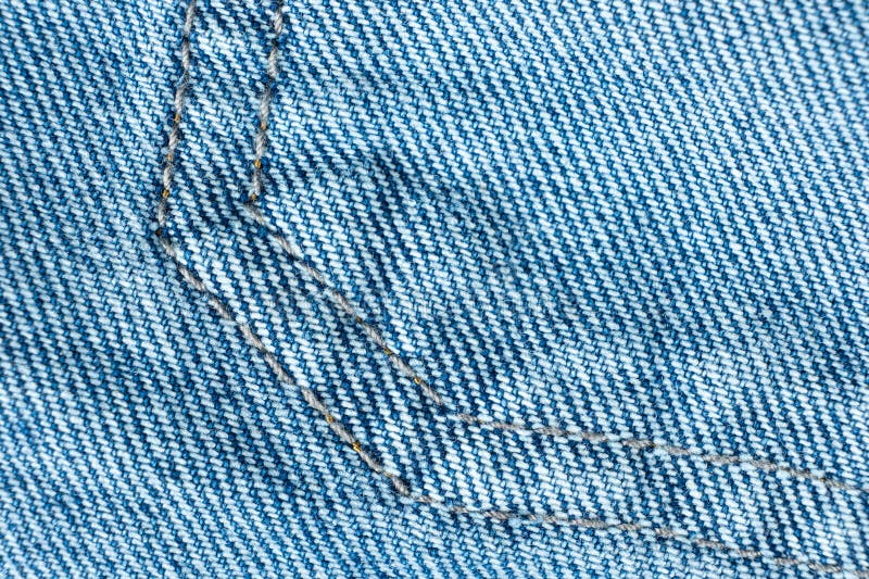 Macro fabric texture of cotton blue jeans. Pocket and thread stitching royalty free stock photo