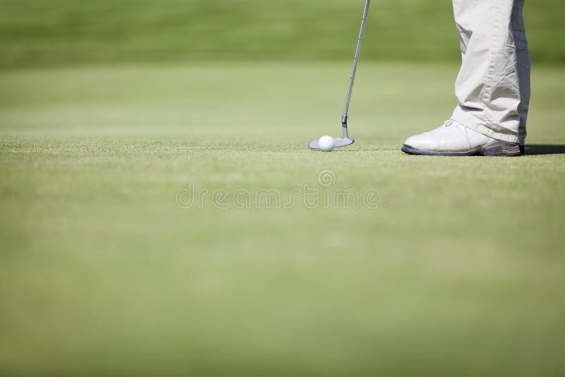 Macro of golf player putting.