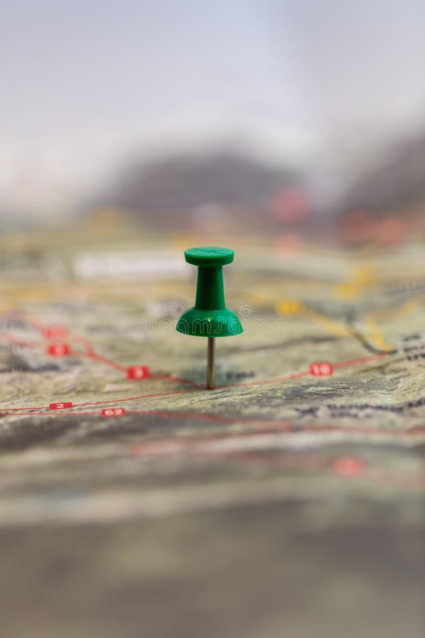 Macro of green pin marks a location of a destination on a map royalty free stock photography