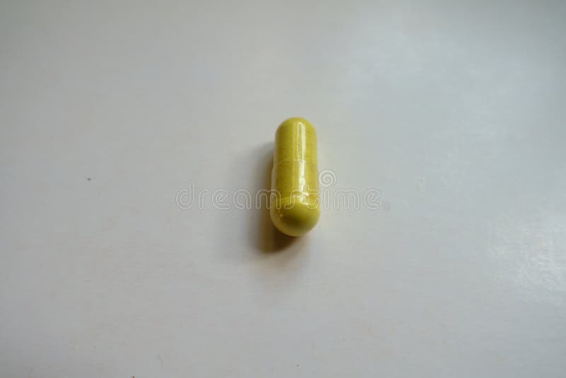 Macro of Greenish Yellow Capsule of Quercetin Dietary Supplement Stock