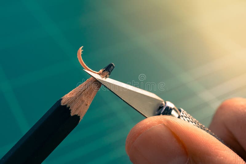 Macro photo de main affilant le crayon émoussé avec le couteau d'art image libre de droits Macro photo de main affilant le crayon émoussé avec le couteau d'art image libre de droits