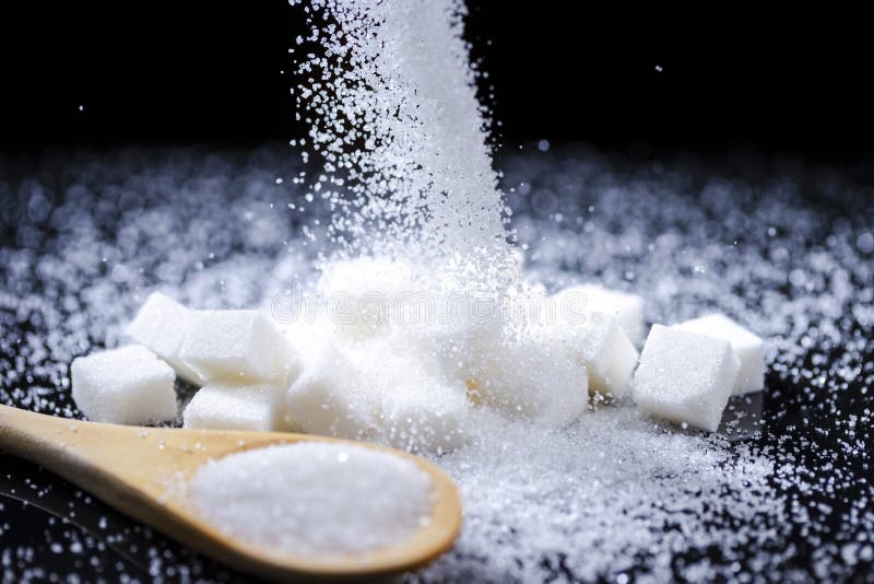 Macro Shoot of White Cube Sugar And Falling Sand Sugar Along With Filled Wooden Measure Spoon. Against Black