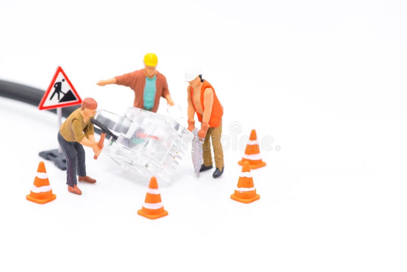 Macro shot on miniature figures as technicians working on the internet web network repair cable socket, isolated on white royalty free stock photos Macro shot on miniature figures as technicians working on the internet web network repair cable socket, isolated on white royalty free stock photos