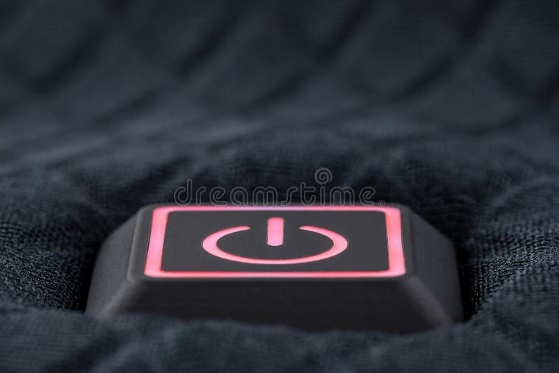 Macro shot of a plastic button with a red power symbol, sewn into modern clothing. Macro shot of a plastic button with a red power symbol, sewn into modern clothing