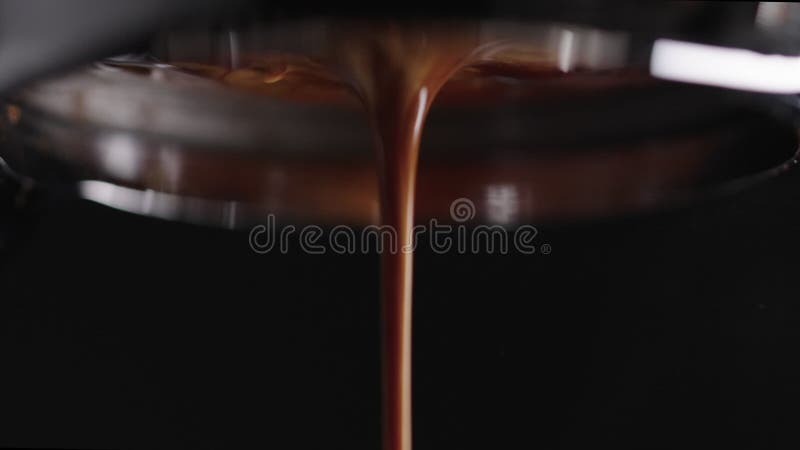 Macro in slow motion scattata per estrarre l'espresso girato con un portafiltro senza fondo