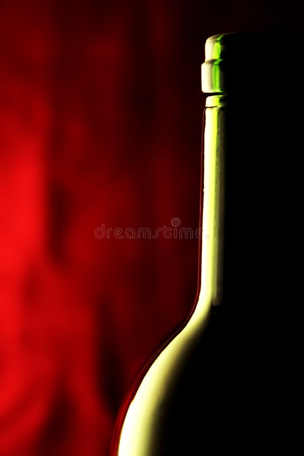 Macro of a wine bottle against a red background