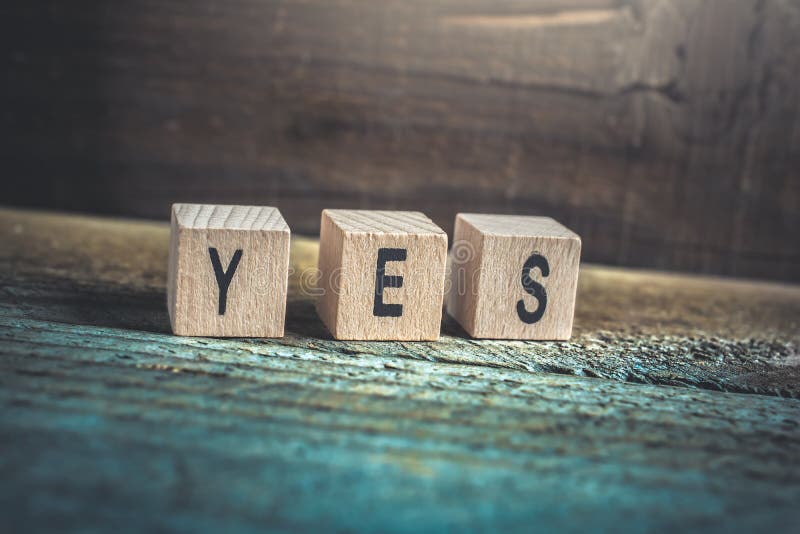 Macro Of The Word Yes Formed By Wooden Blocks On A Wooden Floor