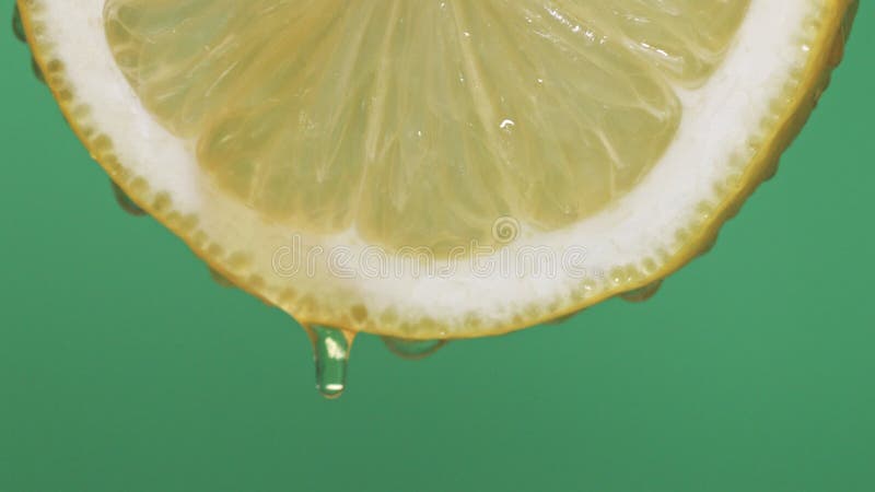 Macro à mouvement lent de la moitié de tranche de citron avec des gouttes de miel visqueux à focale douce tombant du citron sur fo banque de vidéos