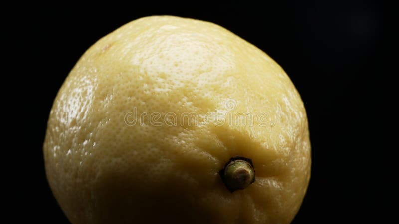 Macrographie d'un citron sur fond noir gras. fermer. comestible. Macrographie la texture complexe d'un citron frais sur un fond noir gras prend le centre de l'étape. chaque plan de fermeture capture les motifs uniques et les détails de la surface des citrons.