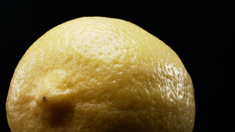 Macrographie d'un citron sur fond noir gras. fermer. comestible. photos stock