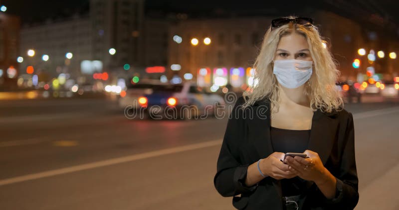 Madame porte le masque protecteur du visage tenant smartphone moderne banque de vidéos