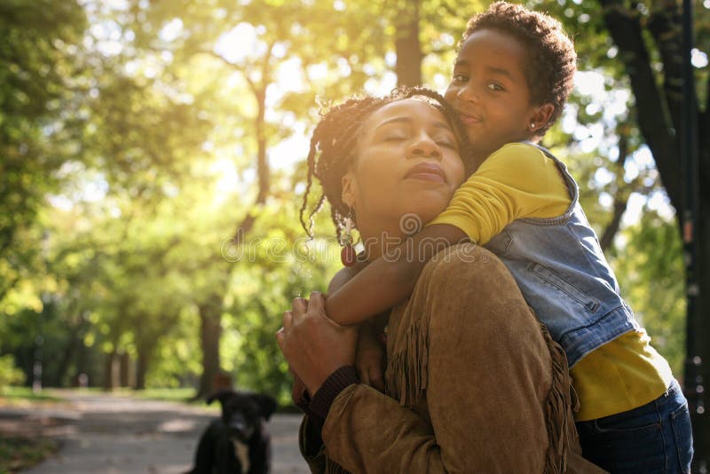 Madre afroamericana y su hija que gozan en togeth del parque imagen de archivo