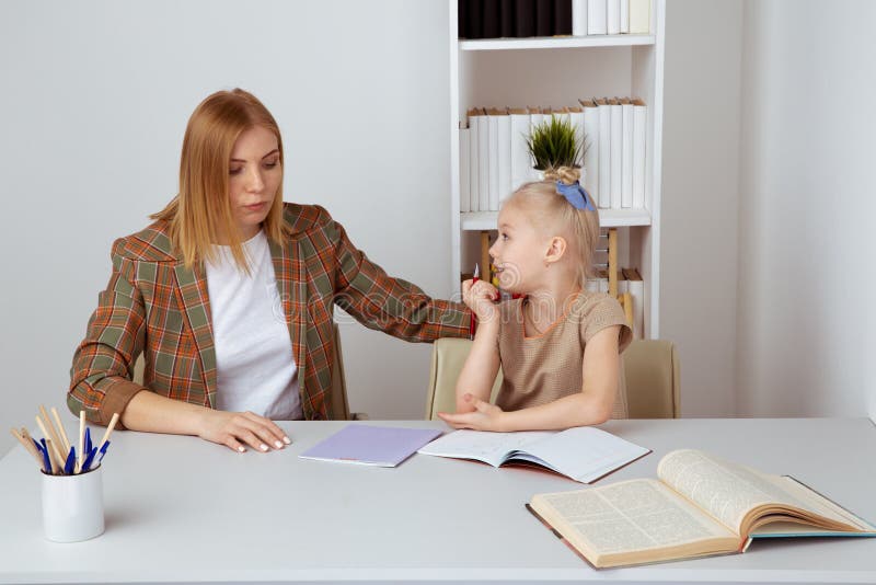 Madre che aiuta poca figlia con compito Concetto di istruzione a domicilio immagini stock Madre che aiuta poca figlia con compito Concetto di istruzione a domicilio immagini stock