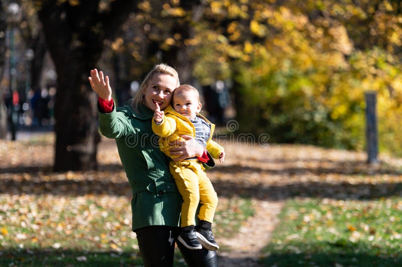 Madre che tiene il figlio in un ritratto autunnale caldo immagine stock