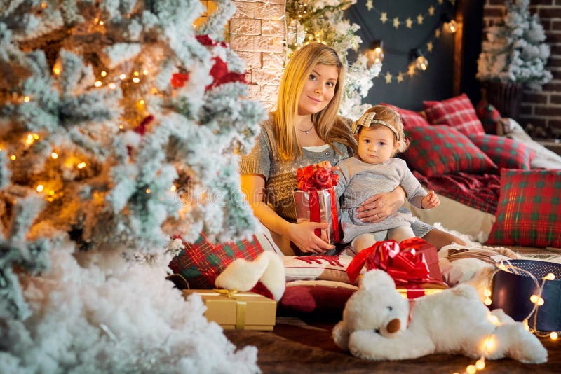 Madre con el bebé en un sombrero de Santa Claus en el cuarto de la Navidad fotografía de archivo Madre con el bebé en un sombrero de Santa Claus en el cuarto de la Navidad fotografía de archivo