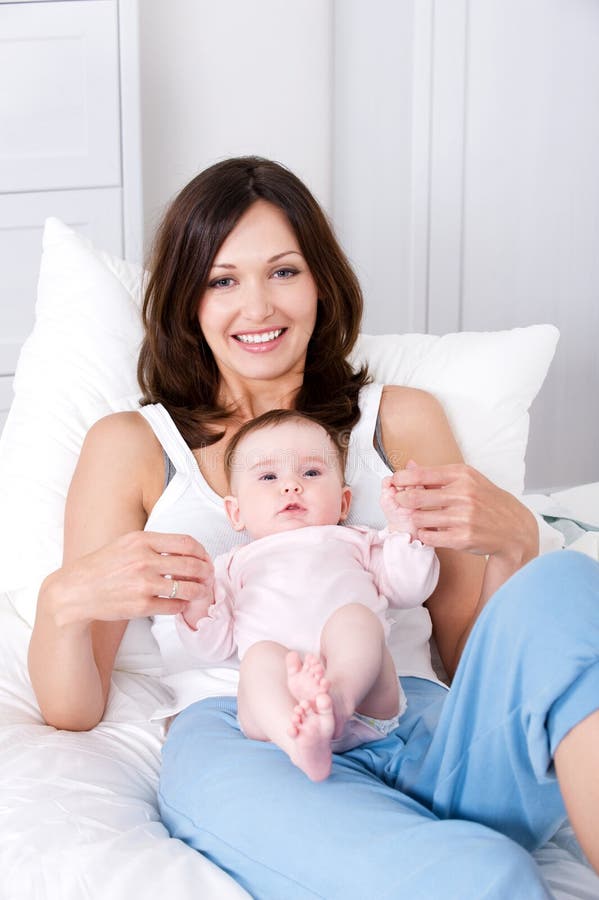 Madre con el bebé que se sienta en el país en casuals imágenes de archivo libres de regalías Madre con el bebé que se sienta en el país en casuals imágenes de archivo libres de regalías