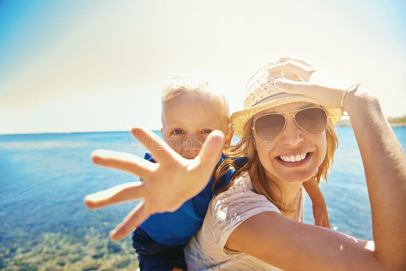 Madre con el pequeño hijo que sonríe en la cámara fotografía de archivo libre de regalías Madre con el pequeño hijo que sonríe en la cámara fotografía de archivo libre de regalías