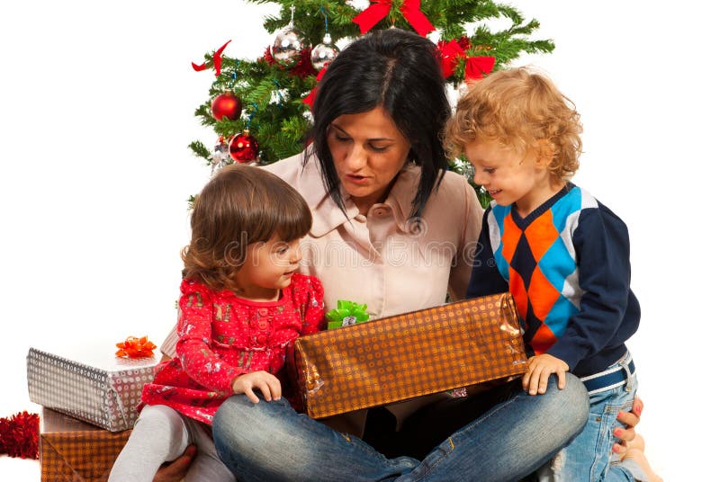 Madre con i bambini sotto l'albero di Natale immagini stock libere da diritti