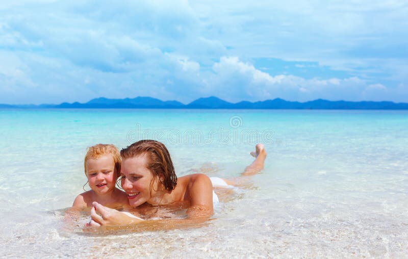 Madre con la neonata sulla spiaggia di estate fotografie stock Madre con la neonata sulla spiaggia di estate fotografie stock