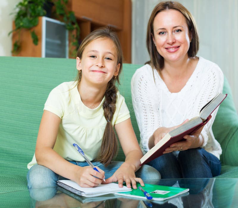 Madre con la piccola figlia che fa compito fotografia stock Madre con la piccola figlia che fa compito fotografia stock