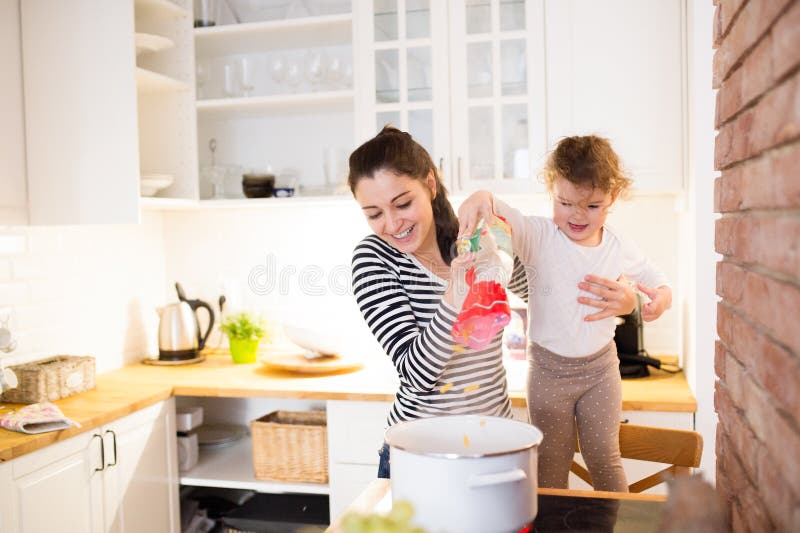Madre con sua figlia nella cucina che cucina insieme fotografie stock Madre con sua figlia nella cucina che cucina insieme fotografie stock