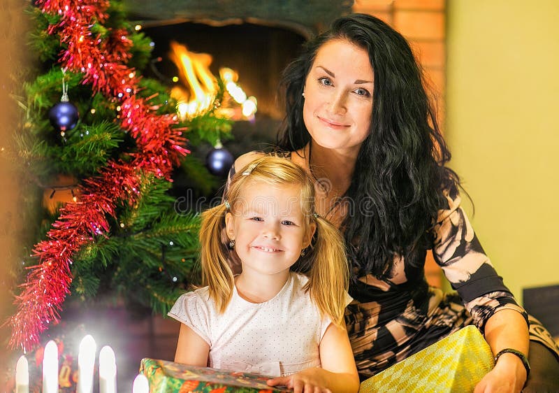 Madre con una hija Cajas de regalos en el fondo del foto de archivo Madre con una hija Cajas de regalos en el fondo del foto de archivo