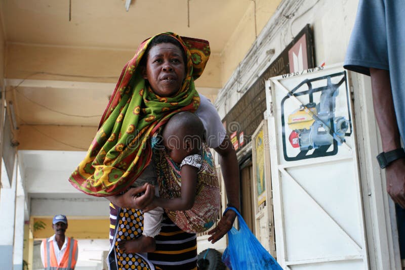 Madre dell'africano nero con un bambino in un'imbracatura fotografie stock libere da diritti Madre dell'africano nero con un bambino in un'imbracatura fotografie stock libere da diritti