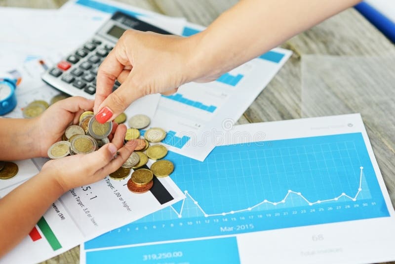Madre e bambino che contano soldi contro i grafici commerciali, parte della lezione finanziaria di istruzione immagine stock libera da diritti Madre e bambino che contano soldi contro i grafici commerciali, parte della lezione finanziaria di istruzione immagine stock libera da diritti