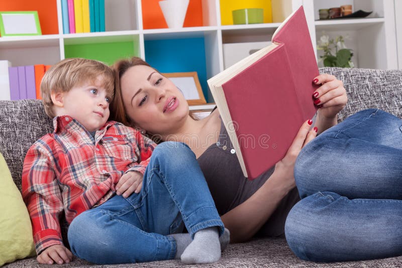 Madre e bambino che leggono un libro immagini stock Madre e bambino che leggono un libro immagini stock