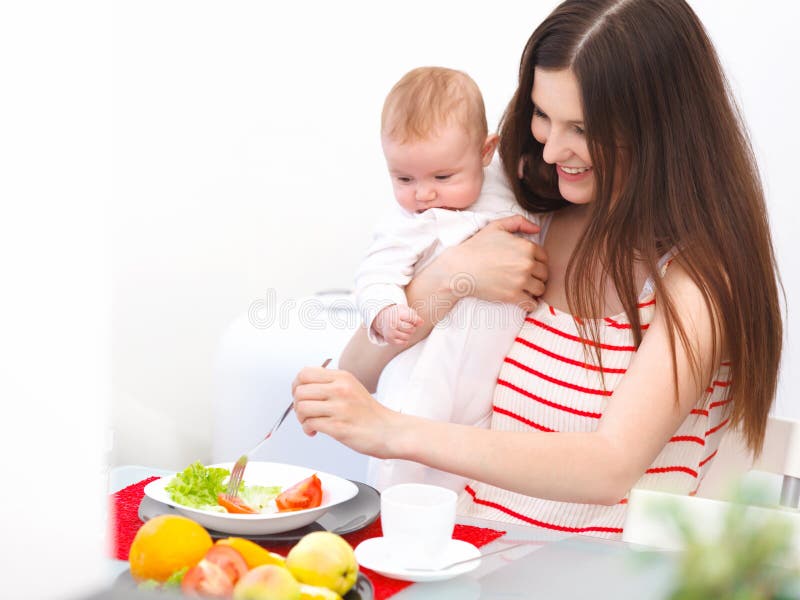 Madre e bambino che mangiano a casa Ritratto sorridente felice della famiglia immagini stock libere da diritti Madre e bambino che mangiano a casa Ritratto sorridente felice della famiglia immagini stock libere da diritti