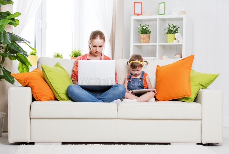 Madre e bambino con il computer e la compressa a casa, secondo immagini stock Madre e bambino con il computer e la compressa a casa, secondo immagini stock