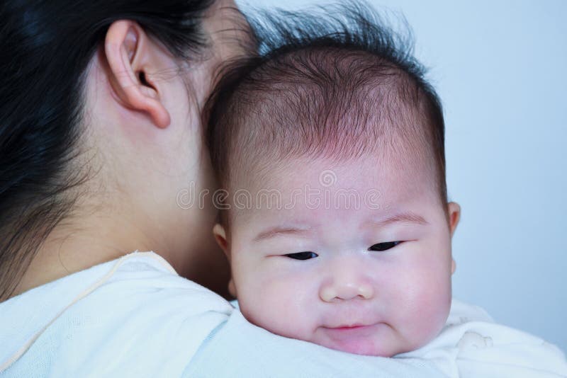 Madre e bambino, ragazza asiatica adorabile che riposa sullo shoul di sua madre fotografia stock libera da diritti Madre e bambino, ragazza asiatica adorabile che riposa sullo shoul di sua madre fotografia stock libera da diritti