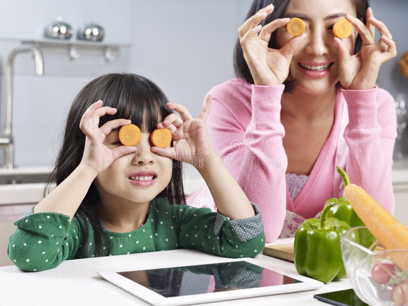 Asian mother and daughter having fun in kitchen. Asian mother and daughter having fun in kitchen.