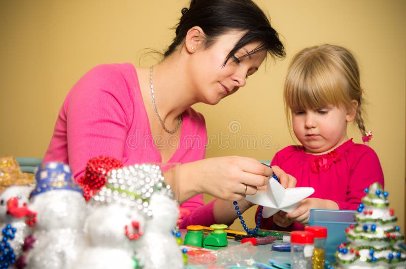 Madre e figlia che fanno le decorazioni di Natale fotografia stock Madre e figlia che fanno le decorazioni di Natale fotografia stock